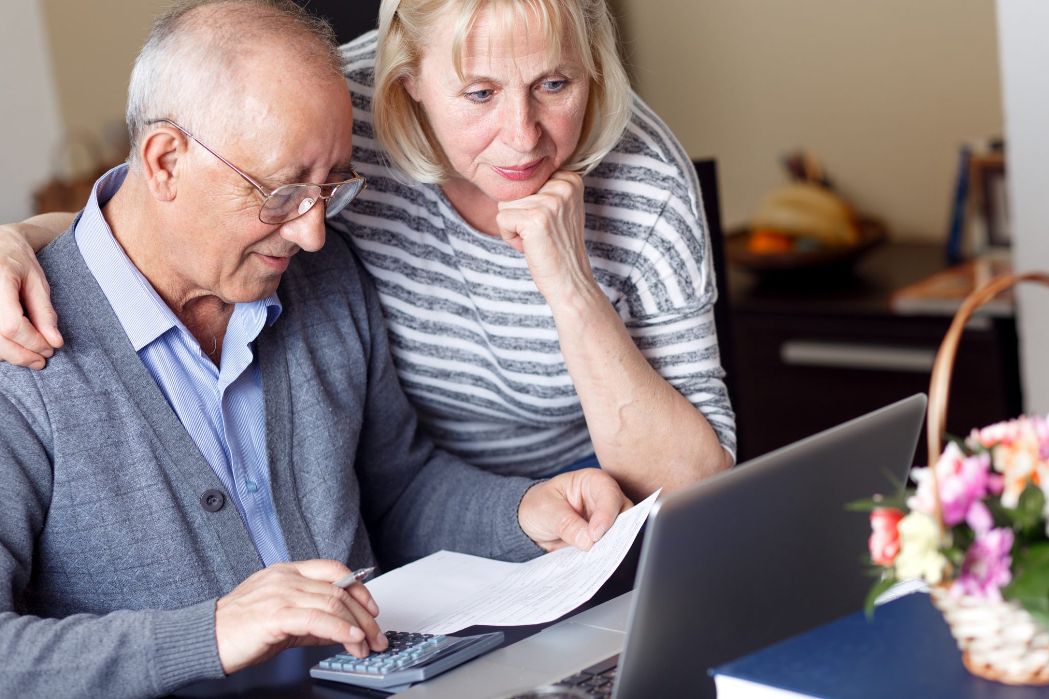 Jim and Sue - Our assets have reduced, what can we do? :Senior couple checking their bills at home