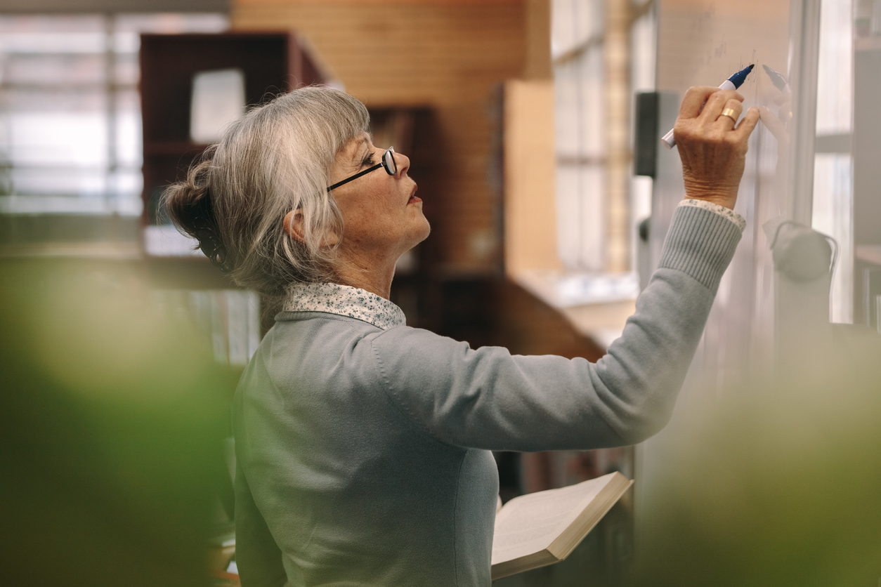 What is your risk tolerance? Senior female lecturer writing on board